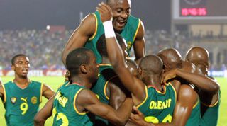 BAMAKO, MALI: Cameroon players celebrate after Salomon Olembe (20) scored against Mali 07 February 2002 during their African Nations Cup semi-final match in Bamako 07 February 2002. AFP PHOTO FRANCK FIFE (Photo credit should read FRANCK FIFE/AFP via Getty Images)