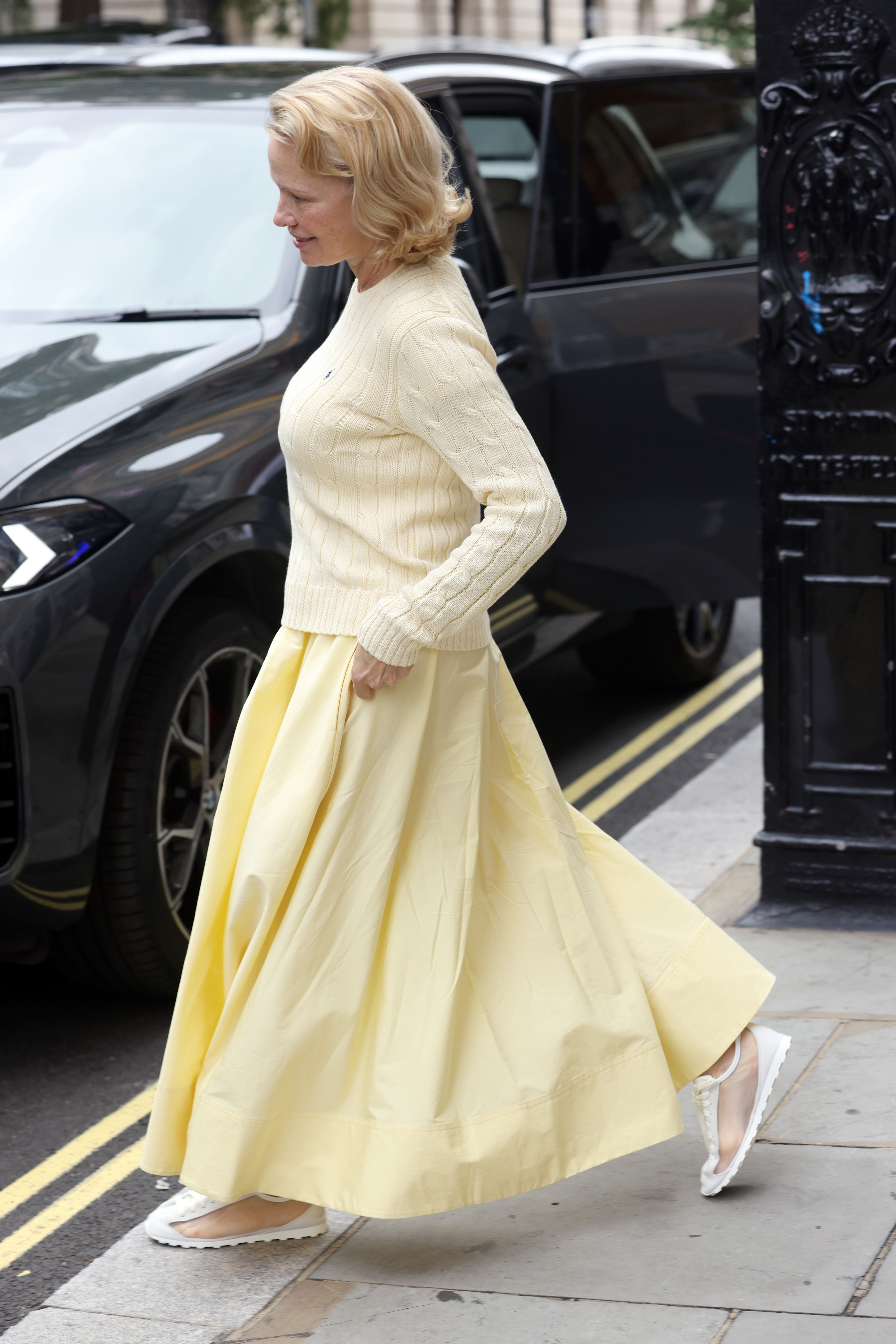 An image of Pamela Anderson showcasing the mesh trainer trend in a pair from Jacquemus.