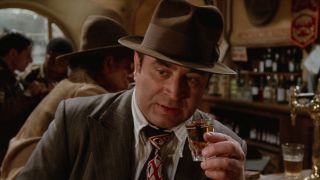 Bob Hoskins holds a shot of bourbon in tribute to a friend in Who Framed Roger Rabbit.