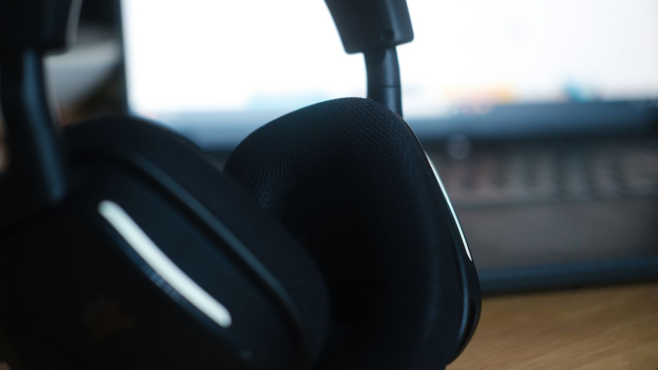 A Corsair Void Wireless V2 gaming headset on a desk and connected to a gaming laptop.