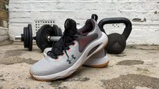 Under Armour HOVR Rise 4 cross training shoes near some weights