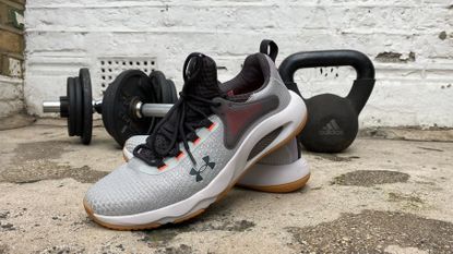 Under Armour HOVR Rise 4 cross training shoes near some weights