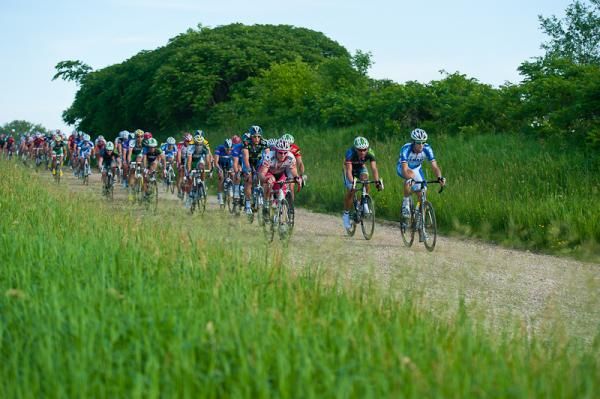 The men's peloton traverses the short dirt section of the course on the way back into town.