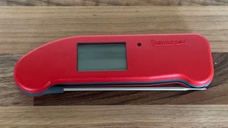 The ThermoWorks Thermapen One closed and not in use on a wooden countertop
