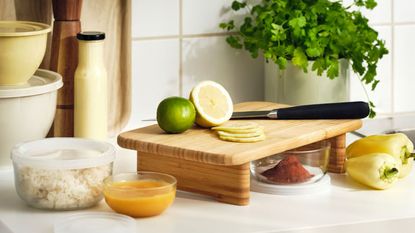 IKEA bamboo raised cutting board on kitchen surface with lemon, lime and a knife