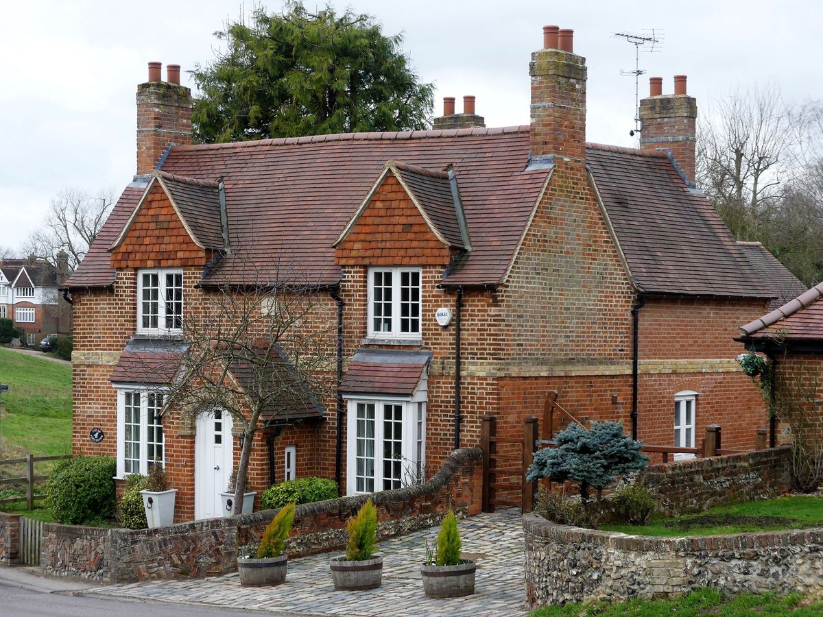 A red brick detached home with brick porch