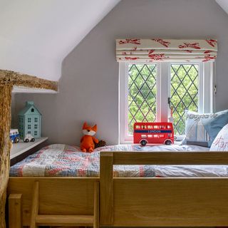 attic childrens room with white wall and wooden bed