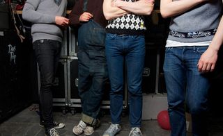 Four men wearing jeans