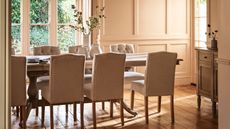 Upholstered dining chairs around a wooden table in a very bright sunny dining room