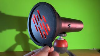 SmallRig RF 10C flashlight held in a hand shining on a greenscreen background