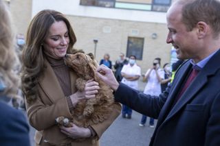 Britain's Catherine, Duchess of Cambridge, watched by her husband Britain's Prince William, Duke of Cambridge, holds a therapy puppy, before unveiling it's name, Alfie, to members of staff during their visit to Clitheroe Community Hospital in north east England on January 20, 2022