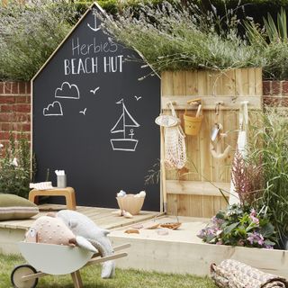 kids garden play area with blackboard, sand box and toys