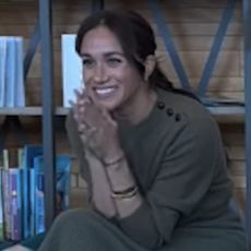 Meghan Markle wears an olive green outfit and a camel trench coat