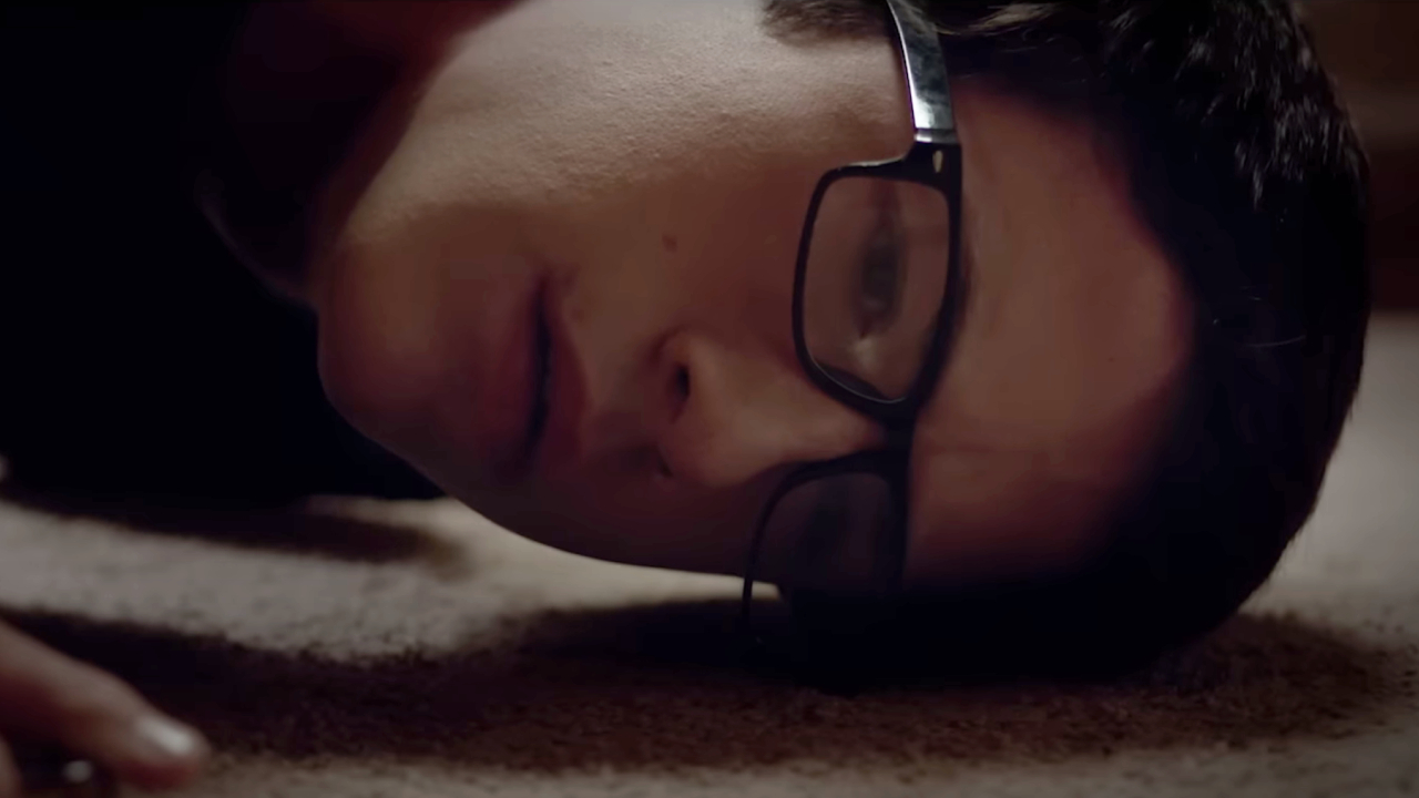 Dylan Minnette placing his ear to the floor in The Open House