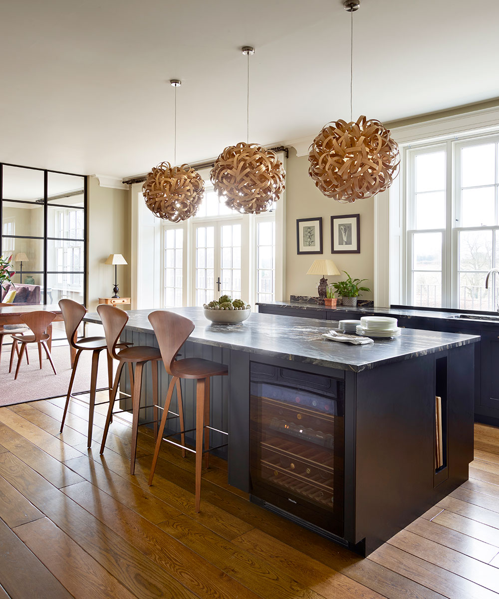 Kitchen island ideas featuring a built-in wine fridge and statement pendant lighting.