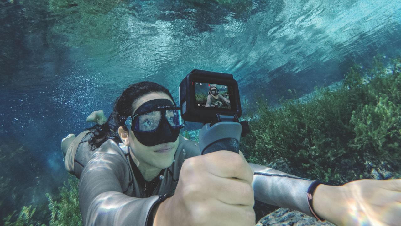 A woman swims underwater while filming using the GoPro Hero6 Black