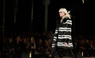 Catwalk model wearing a black and white striped fur coat