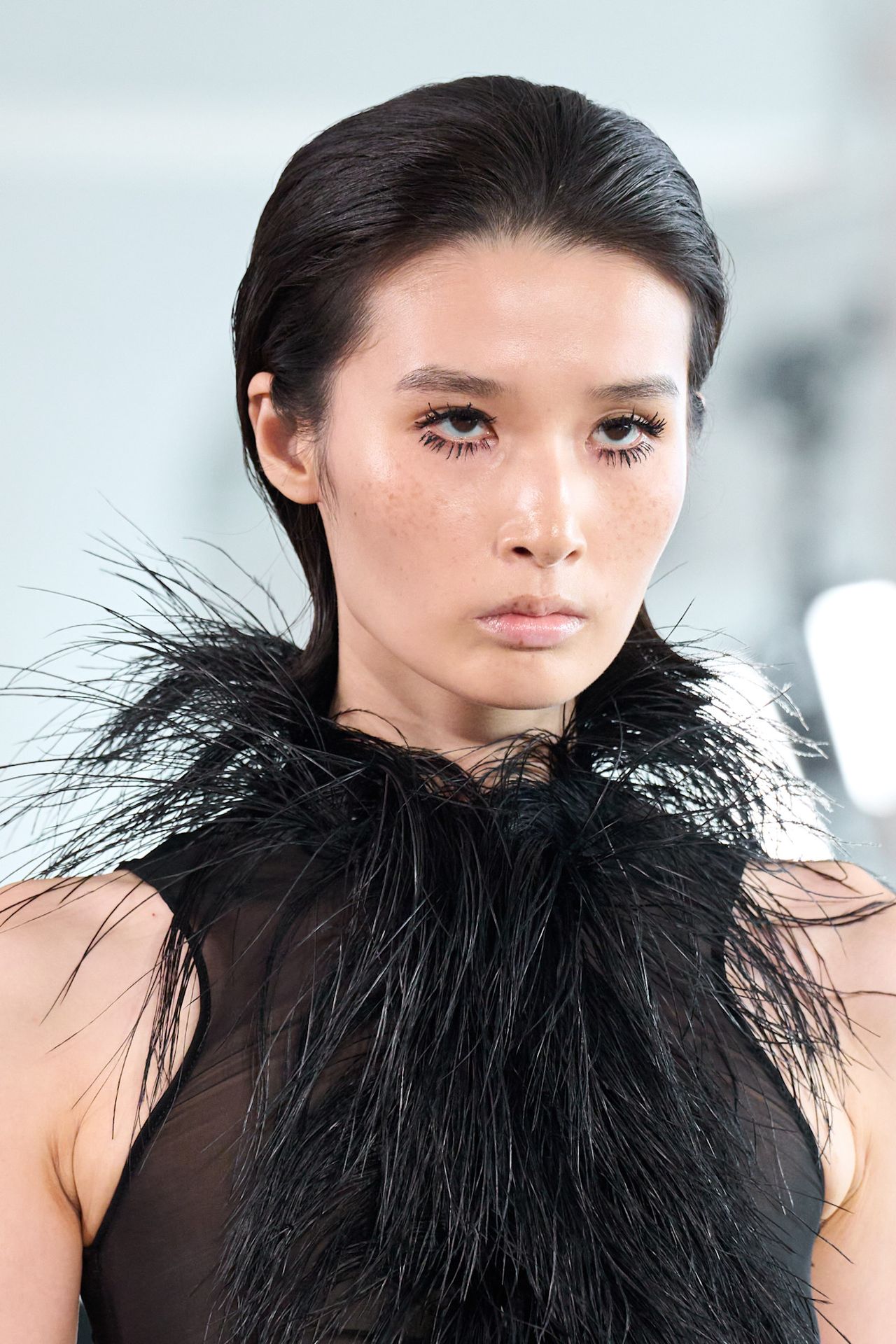 No part on a model in a black feather top at Magda Butrym.