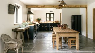 Slate kitchen flooring in a farmhouse kitchen with light wall and wooden beams