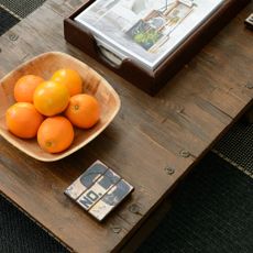 A coffee table with a bowl of oranges