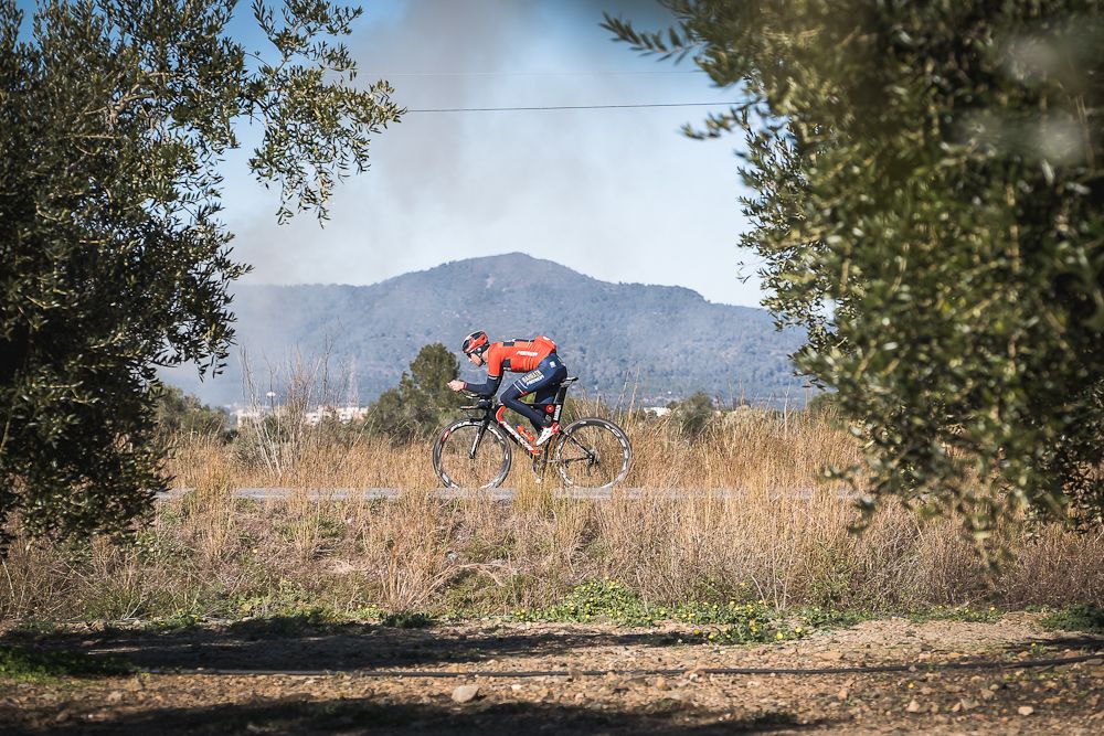 A Bahrain-Merida rider is framed by the flora in Catalunya