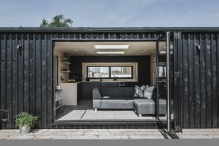black clad cabin garden room with view of kitchen and living room