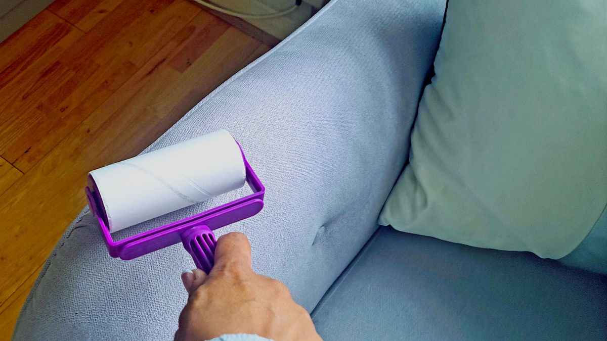 A lint roller being used to clean furniture 