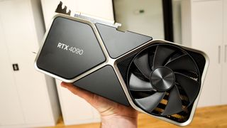 Paras näytönohjain Nvidia RTX 4090 ihmisen kädessä valkoisia kaappeja vasten