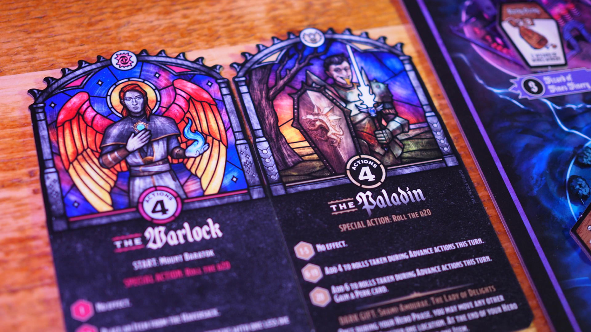 The Warlock and Paladin character class cards on a wooden surface