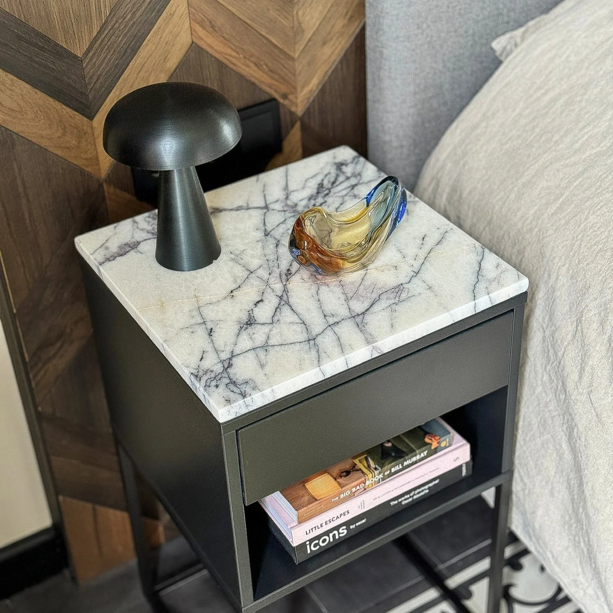 An IKEA bedside table with a marble top
