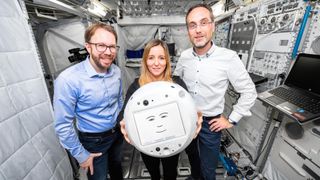The CIMON 2 robot designers at the German Aerospace Center (DLR) pose with their new automaton friend for astronauts.