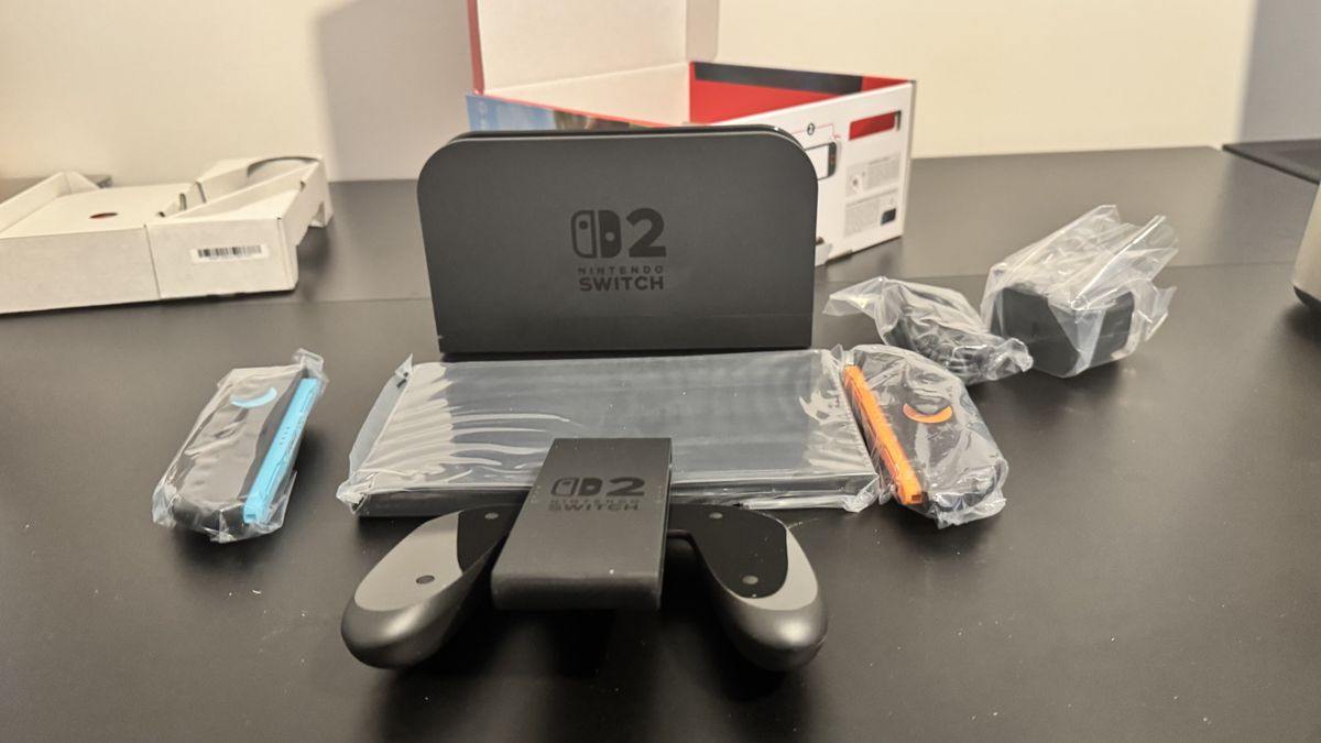 A picture of Nintendo Switch 2 dock with the console in front and the Switch 2 box behind it