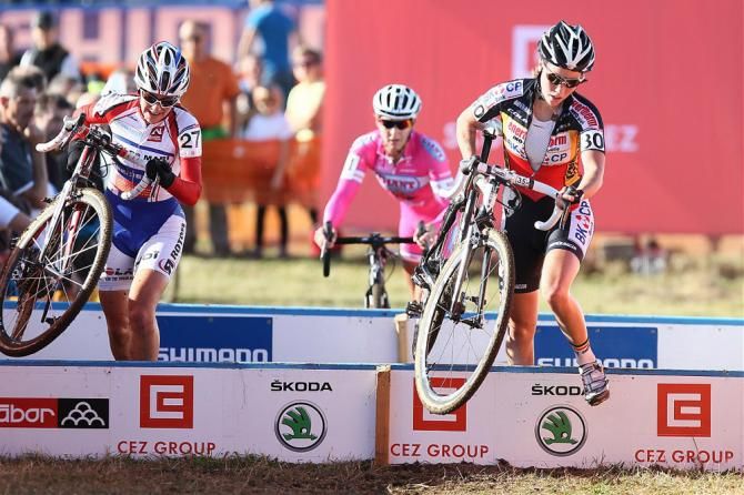 Christel Ferrier-Bruneau, left, and Belgian champion Sanne Cant clear the barriers while Meredith Miller tries to make contact