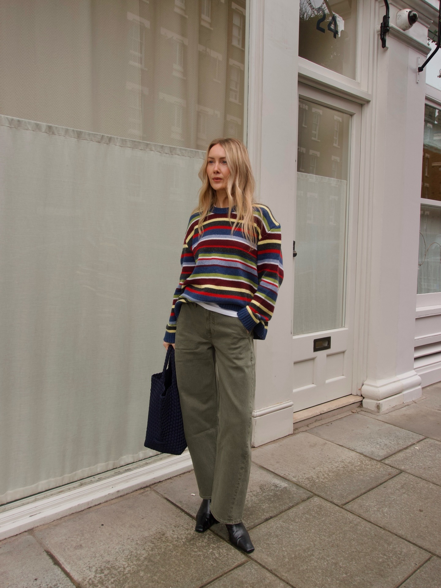 Chloe wears a striped jumper, khaki jeans and black boots