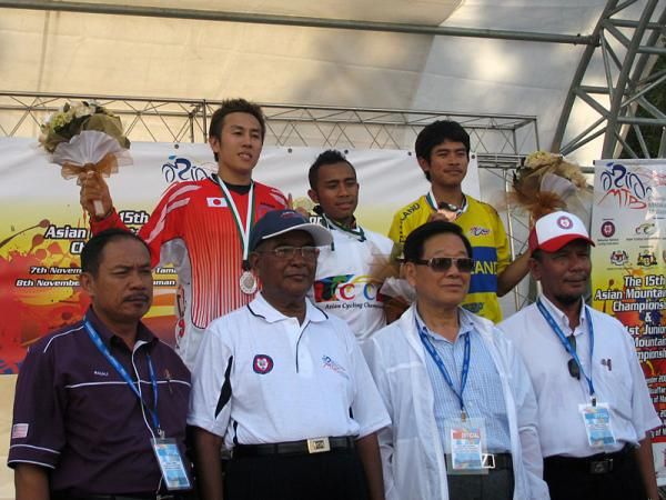 The elite men's downhill podium finishers with event VIPs.