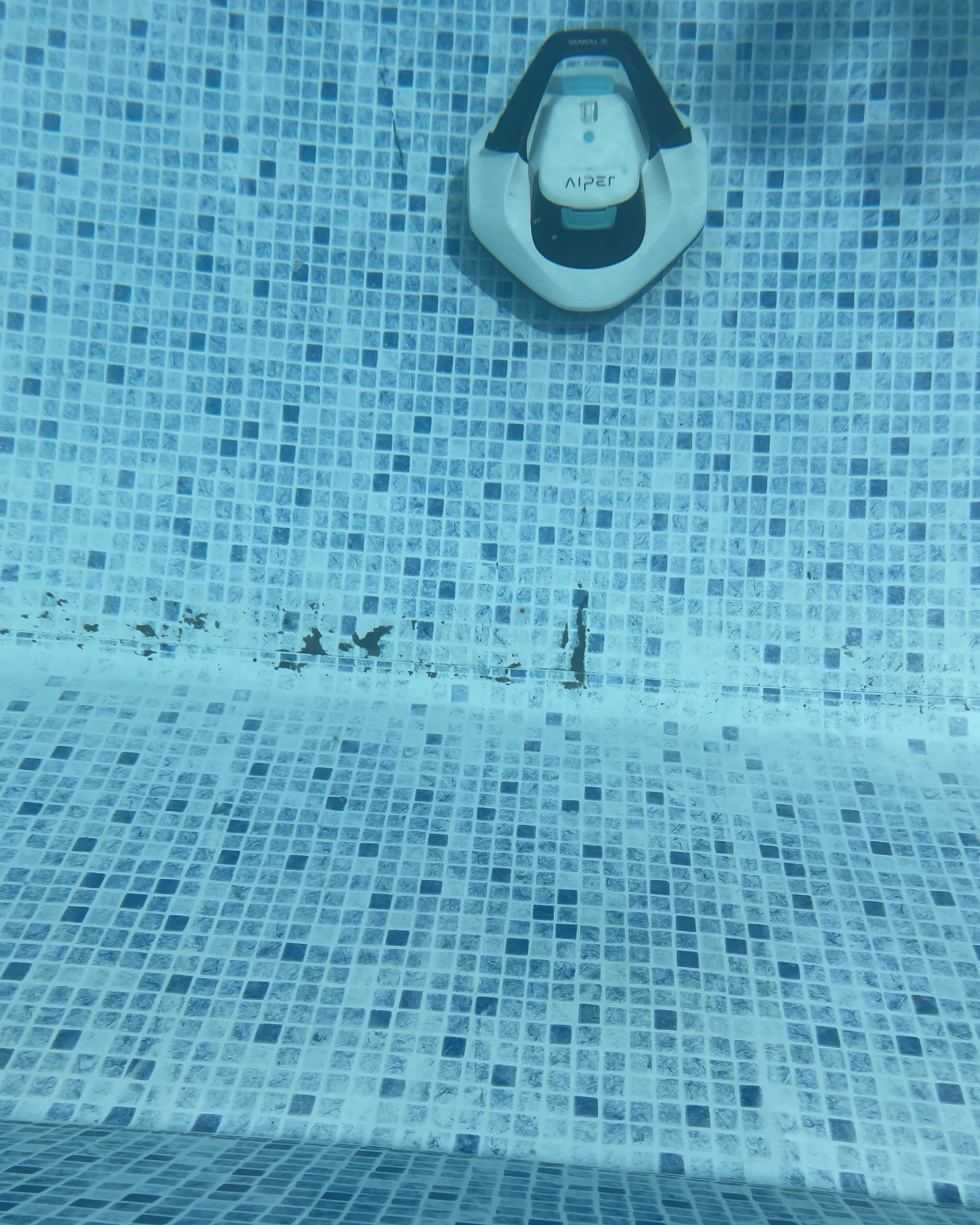 A robot pool cleaner on a dirty floor