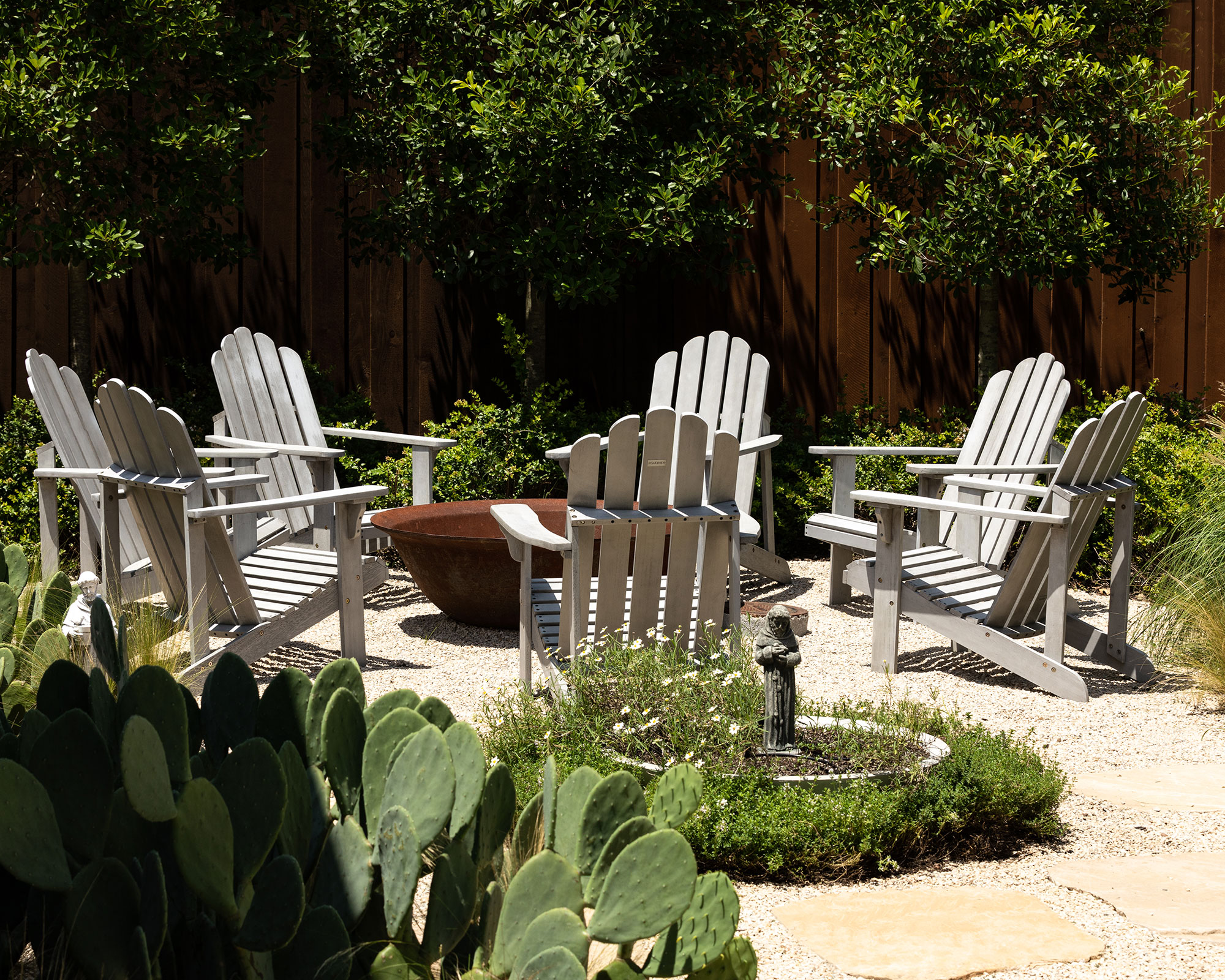 Adirondack chairs arranged in a circle around a metal fire pit