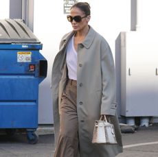 Jennifer Lopez in a tan trench coat and white tee