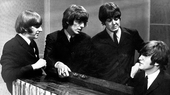 During the recording of a televised program in TV GRANADA studio in Manchester, the four members of the British pop group the BEATLES talking next to the piano, 1962-1965.