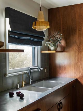 Kitchen with wooden paneling and a steel worktop