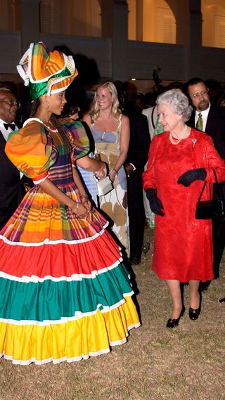 Queen Elizabeth greets a woman in a colourful dress on her Golden Jubilee tour
