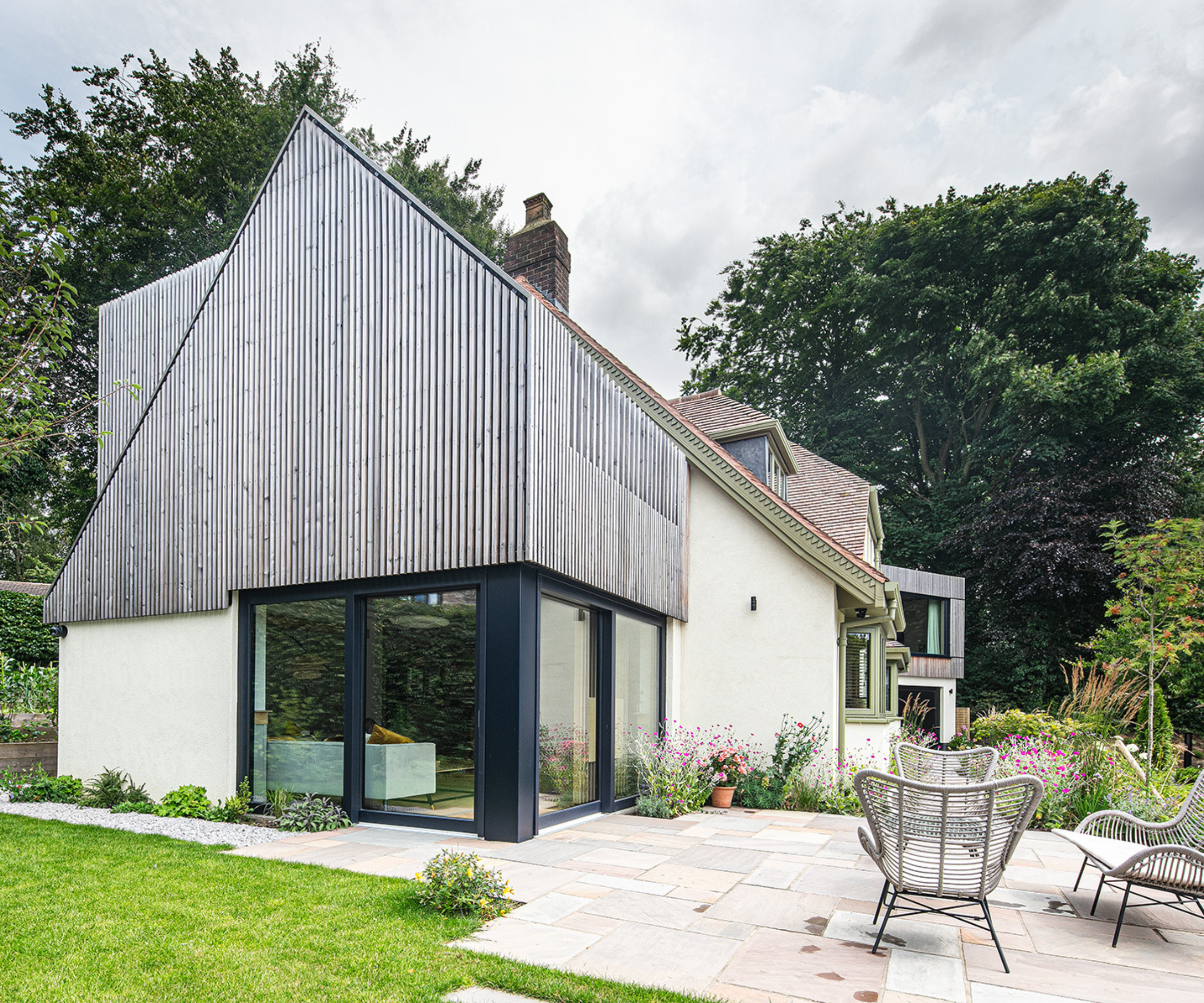 Side view of the property from the patio - cladding at the top and a corner glazed patio doors