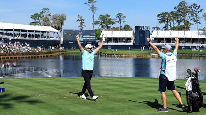 Ryan Fox celebrates with his caddie Dean Smith after his hole in one on the island 17th hole during the first round of the 2024 Players Championship at TPC Sawgrass