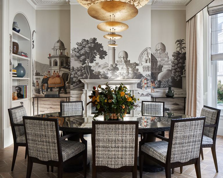 Grey dining room with striking wallpaper mural on one wall, central dinig table with low hanging pendant