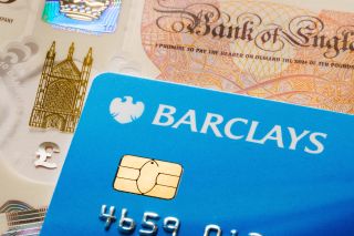 Barclays debit card close-up with British currency. Financial concept highlighting banking services, currency exchange, and digital payments.