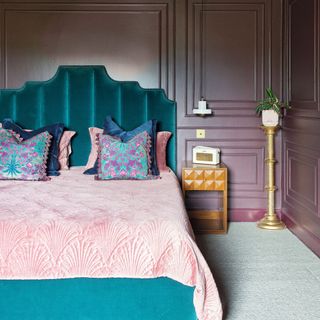 bedroom with vintage bed and teal headboard in front of purple wall panelling