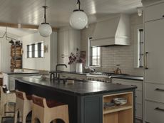 A neutral kitchen with a black island