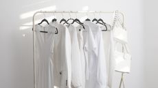 A womans white capsule summer wardrobe in white room
