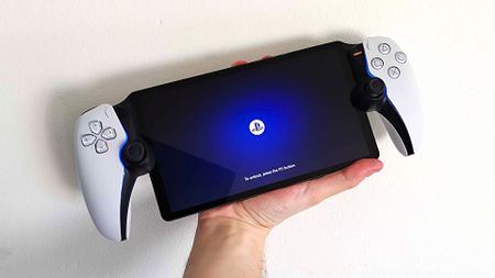 hand holding PlayStation Portal with white backdrop.