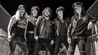 LA Guns standing under a wire bridge